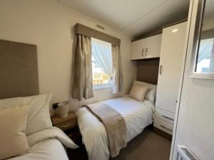 a small bedroom with two beds and a window at Daffy Duck in Tydd Saint Giles +16 photos