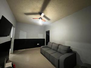 a living room with a couch and a ceiling fan at Casa Completa brutomesso 3 in Londrina