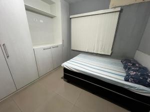 a small bedroom with a bed and a window at Casa Completa brutomesso 3 in Londrina