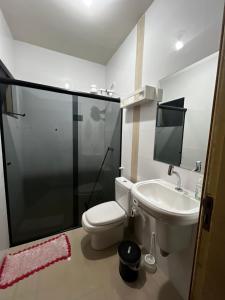 a bathroom with a toilet and a sink and a shower at Casa Completa brutomesso 3 in Londrina