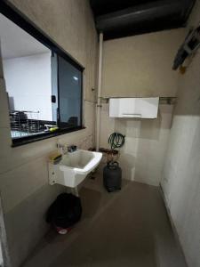 a small bathroom with a sink and a window at Casa Completa brutomesso 3 in Londrina