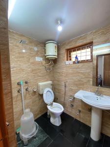 a bathroom with a toilet and a sink at Nagwal Hotel in Dharamshala +17 photos