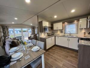 a kitchen and living room with a table in a caravan at Daffy Duck in Tydd Saint Giles