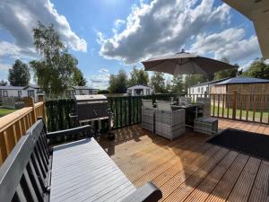 a deck with a grill and an umbrella at Daffy Duck in Tydd Saint Giles