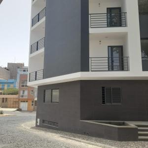 a tall building with balconies on the side of it at Rita Apartamento in Mindelo