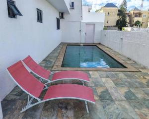 a pair of chairs sitting next to a swimming pool at Label résidence 2 in Grand-Baie