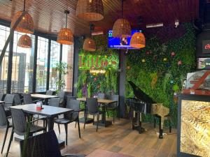 ein Restaurant mit einer grünen Wand, ausgestattet mit Tischen und Stühlen in der Unterkunft Hotel Chiavari in San Bernardo