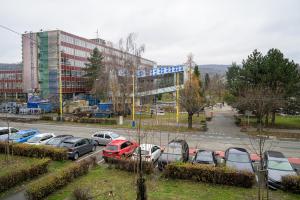 a parking lot with cars parked in front of a building at Birdhouse Apartments in Prešov