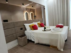 a bedroom with a large bed with red and yellow pillows at Ursino inn camere e suite in Catania