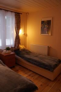 a bedroom with a bed and a window at Domek nad Narwią in Zatory