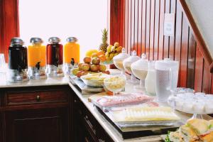 a buffet of food on a counter with fruit and juice at Central Park Hotel São Carlos - Fácil Acesso USP e Industrial - Ar condicionado in São Carlos +29 photos