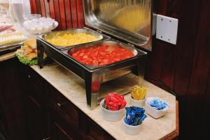 a buffet with two trays of food on a counter at Central Park Hotel São Carlos - Fácil Acesso USP e Industrial - Ar condicionado in São Carlos