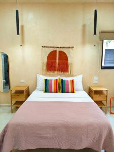 a bedroom with a large bed with colorful pillows at Villa Lara Palacios, tu oasis en Mérida in Mérida