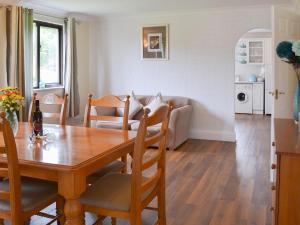 a dining room and living room with a wooden table at Rosecraddoc Manor - Lakeview in Saint Cleer