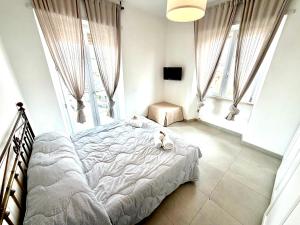 a white dog laying on a bed in a bedroom at Italy House in Ladispoli