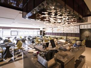 a lobby of a restaurant with tables and chairs at Mercure Panjin in Panjin