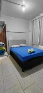 a bedroom with a bed with two shoes on it at Pousada Familiar 04 in Rio do Sul