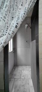 a bathroom with a shower and a white curtain at Pousada Familiar 04 in Rio do Sul