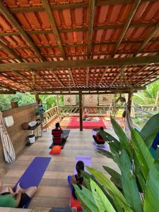 a group of people sitting in a yoga class at Hospedagem Arte na Cura in Guarapari