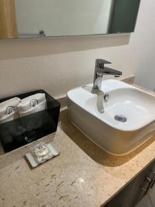 a bathroom counter with a sink and a mirror at HUNICO HOTEL in Tulancingo +39 photos