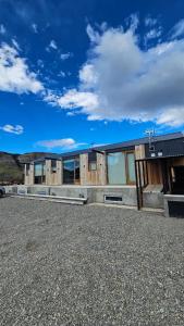 a building on a gravel road with a sky at Las Loicas Chalten Apart in El Chalten