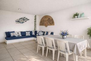 a dining room with a table and a blue couch at Departamento en Marina Diamante con lago y alberca in Acapulco