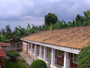 a house with a tile roof with trees in the background at Kivu Hotel Resort in Kibuye