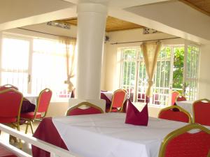 a room with a table with red chairs and windows at Kivu Hotel Resort in Kibuye