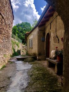 an alley with a stone building with a bench at Viandanti, Artisti e Sognatori in Comano +58 photos