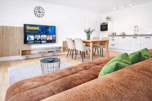 a living room with a couch and a table at Nivas Collection - Neubau Luxus Apartment in Montabaur