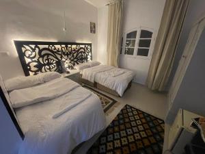 a hotel room with two beds and a mirror at Toutankhamon in Luxor