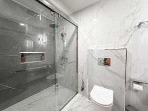 a bathroom with a glass shower and a toilet at TideViewInn in Gaafaru +11 photos