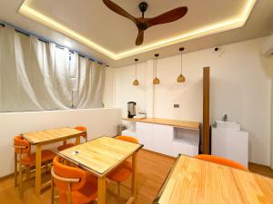 a dining room with two tables and orange chairs at TideViewInn in Gaafaru