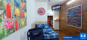 a room with a couch and a tv and a painting at Casa Del Chef Lupita in Campeche