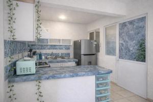 a kitchen with a blue counter top and a refrigerator at Departamento en Marina Diamante con lago y alberca in Acapulco +4 photos