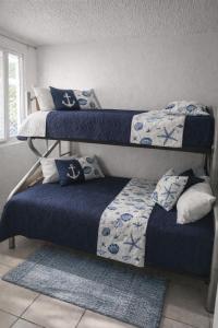 a bedroom with three bunk beds and a rug at Departamento en Marina Diamante con lago y alberca in Acapulco