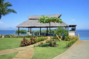 a gazebo with a straw roof on the beach at Departamento en Marina Diamante con lago y alberca in Acapulco