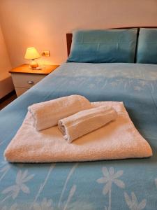a bed with two towels on top of it at Ai Volardi Apartment in Torre di Santa Maria
