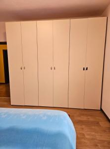 a bedroom with white cabinets and a bed at Ai Volardi Apartment in Torre di Santa Maria