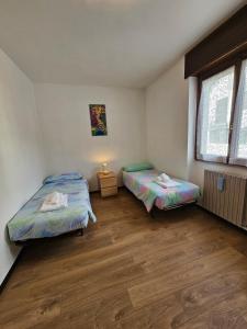 a bedroom with two beds and a window at Ai Volardi Apartment in Torre di Santa Maria +11 photos