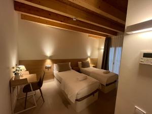a hotel room with two beds and a table and a desk at Hotel luna nueva in Tarragona +27 photos