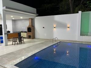 a swimming pool with blue lights in a house at Casa Ampla e aconchegante Limoeiro in Limoeiro