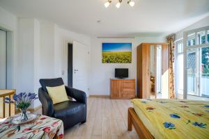 a bedroom with a bed and a chair and a television at FH Luisenlund im Ostseebad Prerow in Prerow