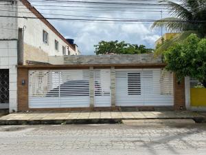 a garage with white doors on a building at Casa Ampla e aconchegante Limoeiro in Limoeiro