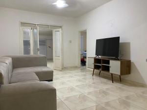 a living room with a couch and a flat screen tv at Casa Ampla e aconchegante Limoeiro in Limoeiro