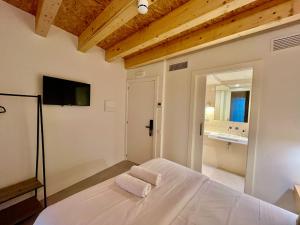 a bedroom with a bed with two towels on it at Hotel luna nueva in Tarragona
