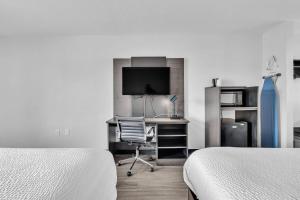 a bedroom with two beds and a desk with a computer at Baymont by Wyndham Rock Hill in Rock Hill