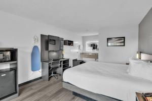a hotel room with a bed and a desk and a computer at Baymont by Wyndham Rock Hill in Rock Hill