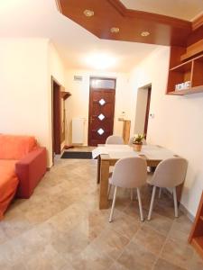 a living room with a table and chairs and a couch at Mami Apartman in Zalakaros