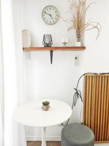 a white table and a chair and a clock on a wall at Best 10th floor Condo Studio at The Loop Limketkai Center Lucky 4 in Cagayan de Oro